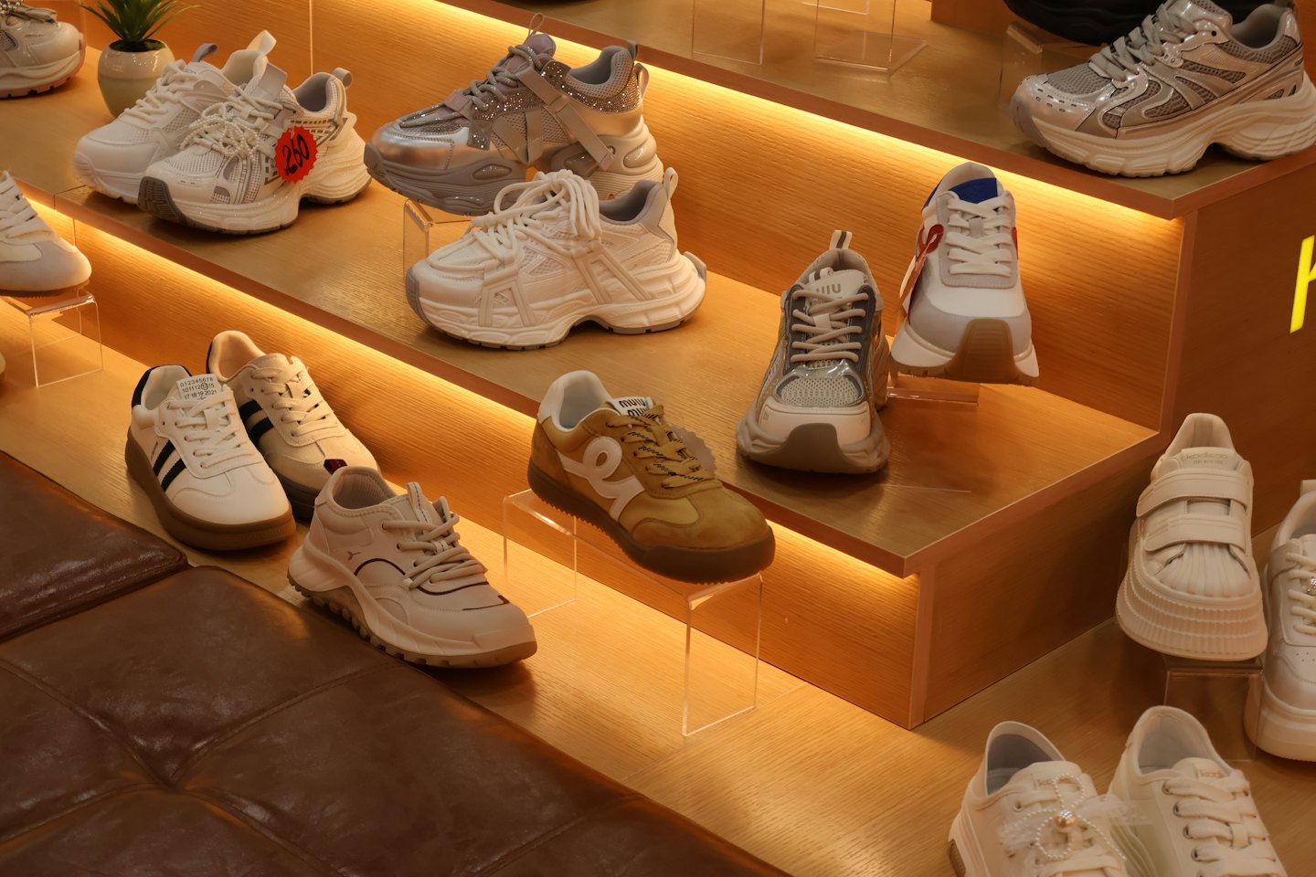 Various athletic sneakers arranged on wooden store shelves.