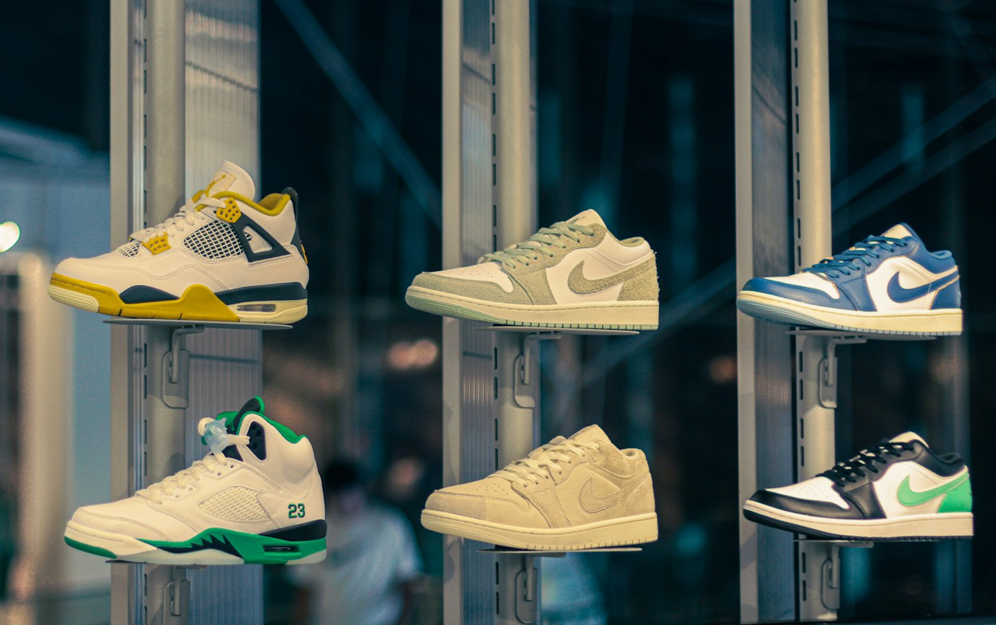 Six pairs of colorful athletic sneakers displayed on retail wall shelves.